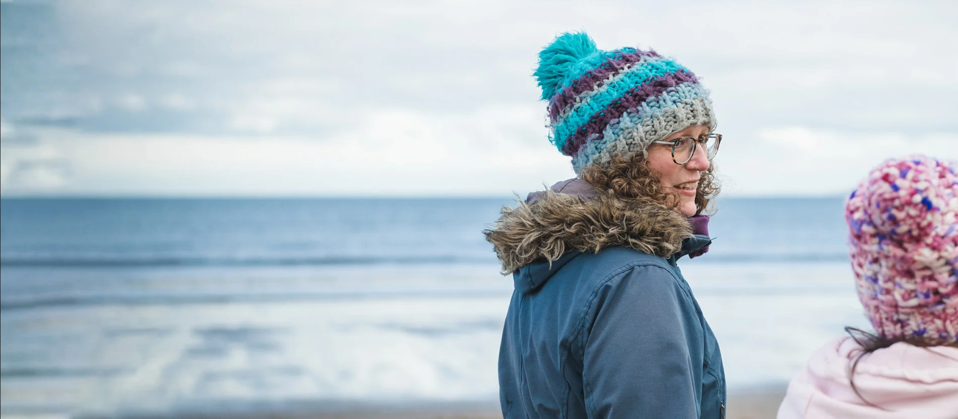 Integrative therapist & life and career coach, Lorna Lythgoe, walks along Portobello beach in Edinburgh while talking with someone