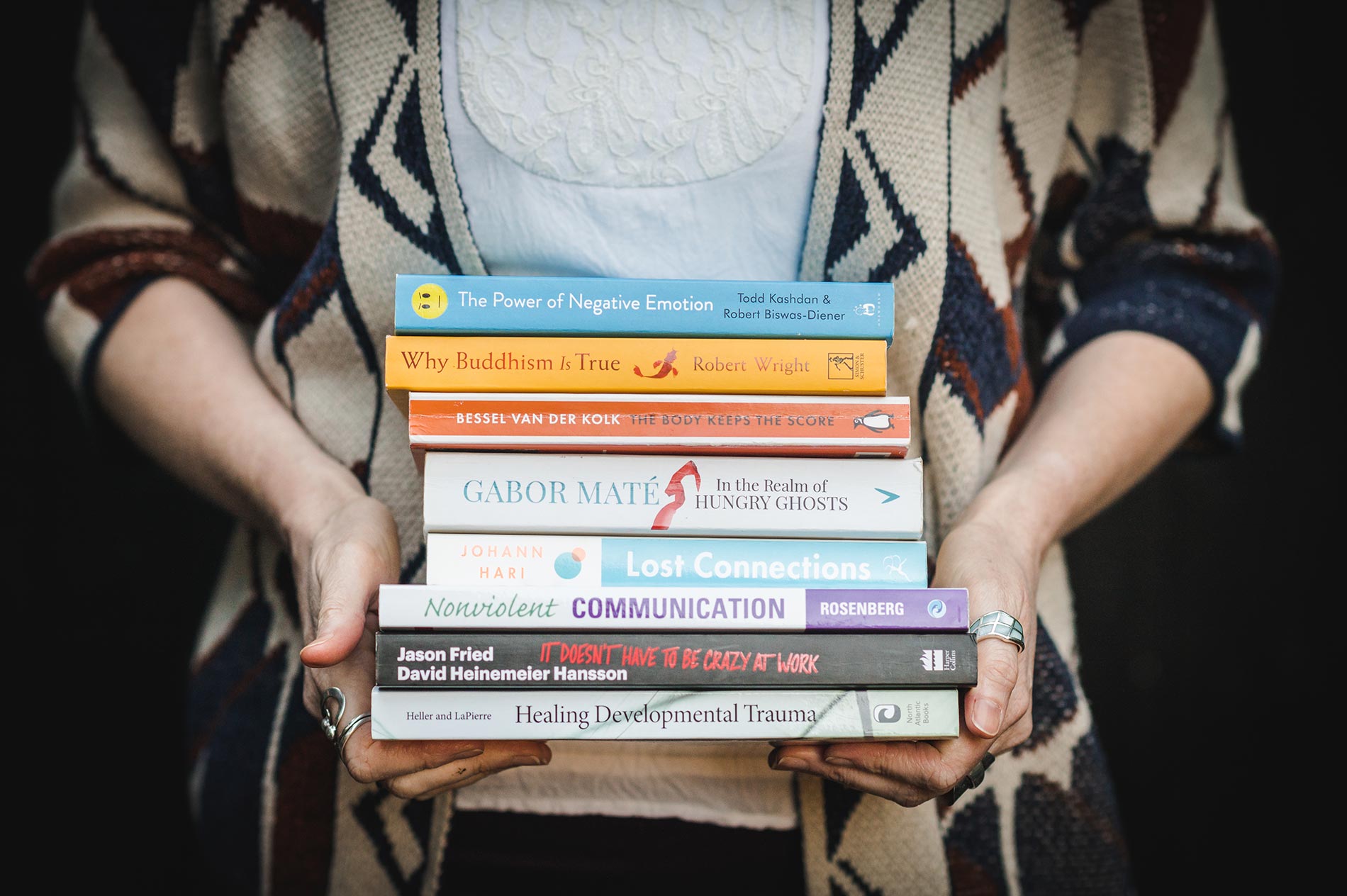 Life and career coach & counsellor, Lorna Lythoge, holds a stack of psychology books on the Counselling and Coaching Fees and FAQs page