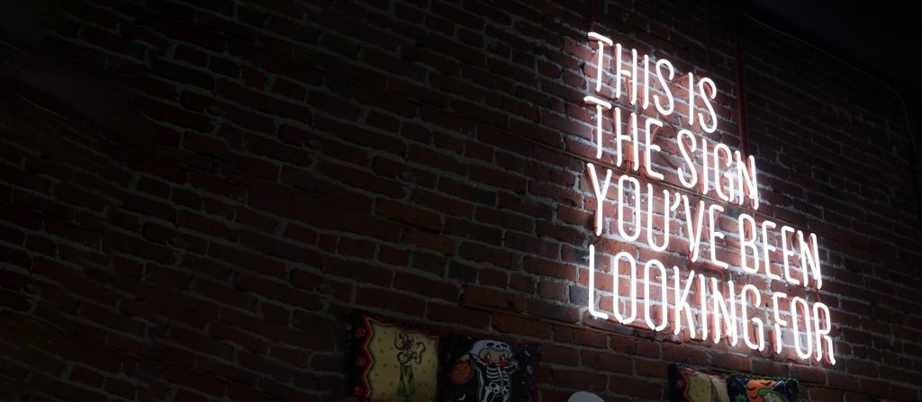 Neon sign saying "This is the sign you have been looking for" on a webpage about a resilence course to manage stress called Feeling Good: The Science of Everyday Resilience